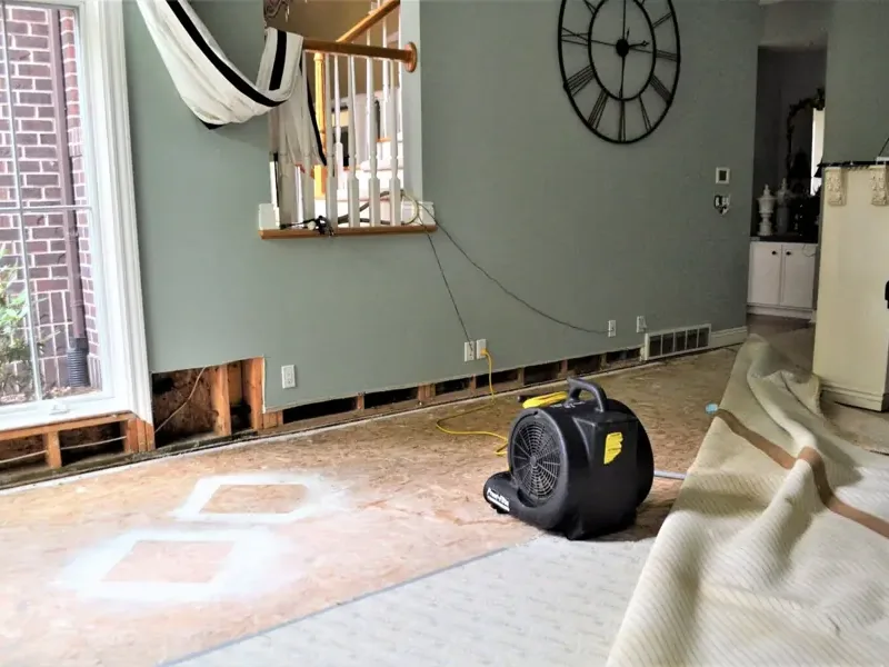 A restoration crew setting up drying equipment in a water-damaged home