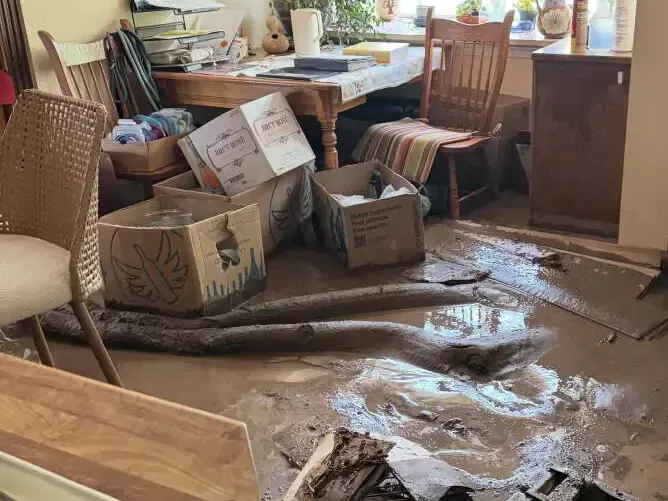 Muddy floodwater spread across a room floor after a flash flood