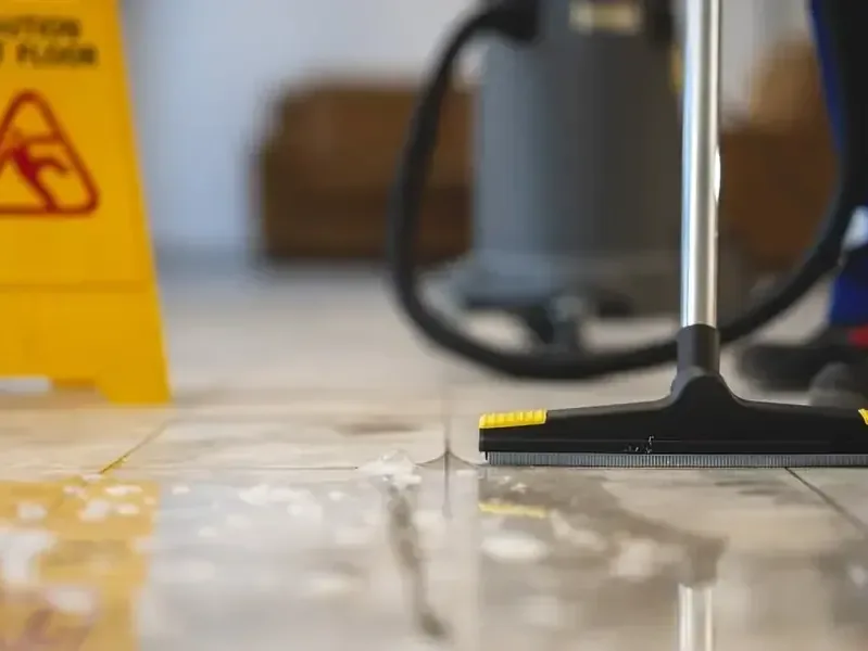 A technician pulling standing water off a floor with an extraction wand